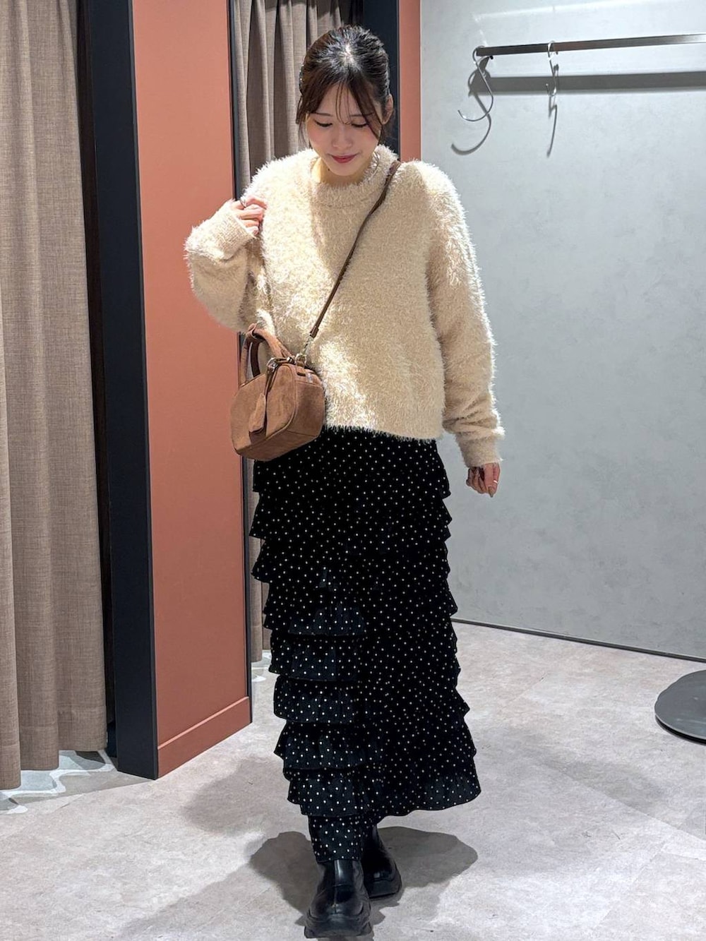 ブラック系のブーツ、その他のスカート、ブラウン系のボストンバッグを着用したレディースの秋コーディネートの4枚目の写真