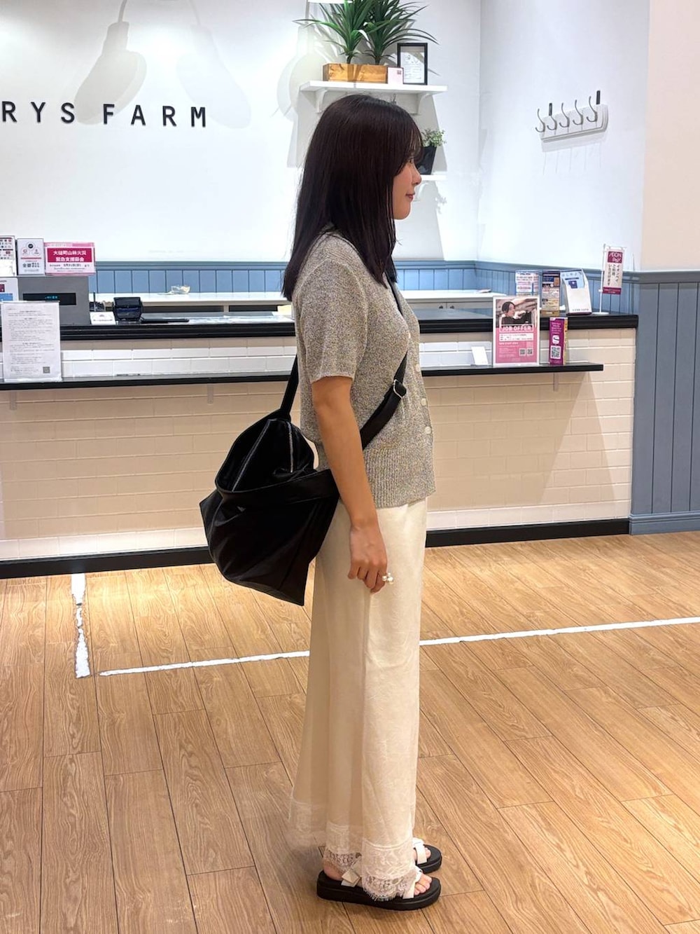 ホワイト系のサンダル、グレー系のTシャツ/カットソー、ブラック系のショルダーバッグを着用したレディースの春コーディネートの2枚目の写真
