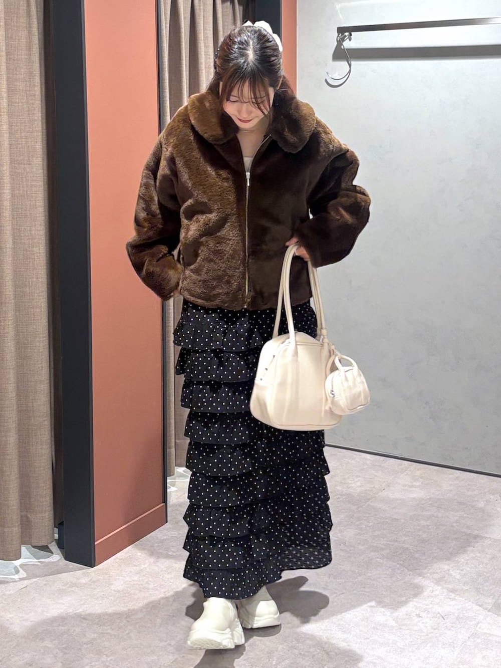 ホワイト系のブーツ、ブラウン系のブルゾン、その他のスカートを着用したレディースの冬コーディネートの4枚目の写真