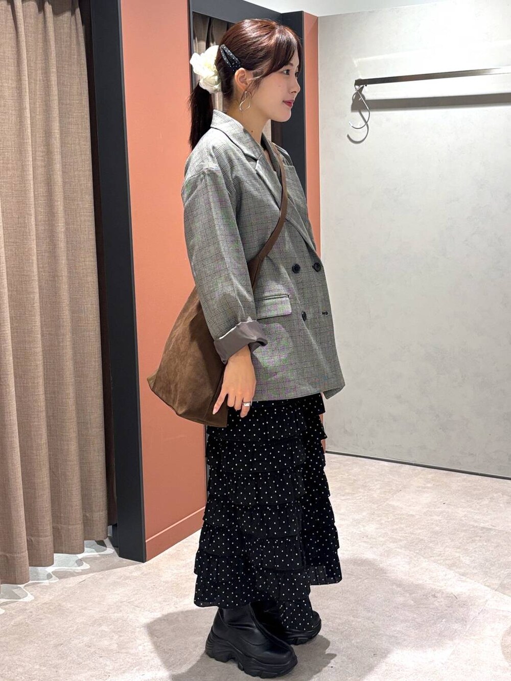 ブラウン系のショルダーバッグ、ブラック系のブーツ、グレー系のテーラードジャケットを着用したレディースの秋コーディネートの2枚目の写真