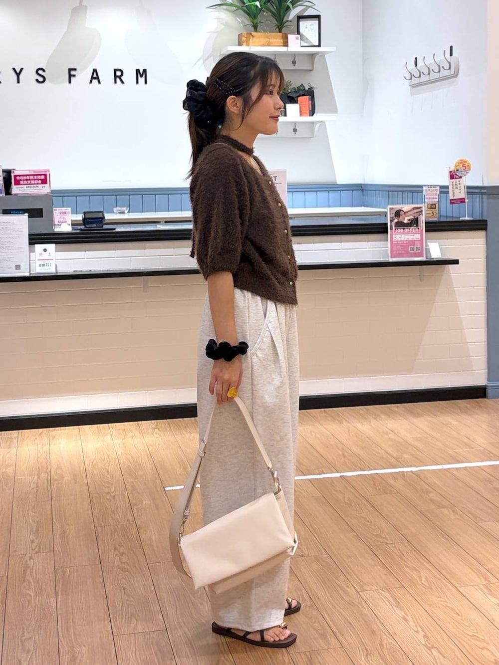 ホワイト系のショルダーバッグ、ブラウン系のカーディガン/ボレロ、グレー系のスウェットパンツを着用したレディースの夏コーディネートの2枚目の写真
