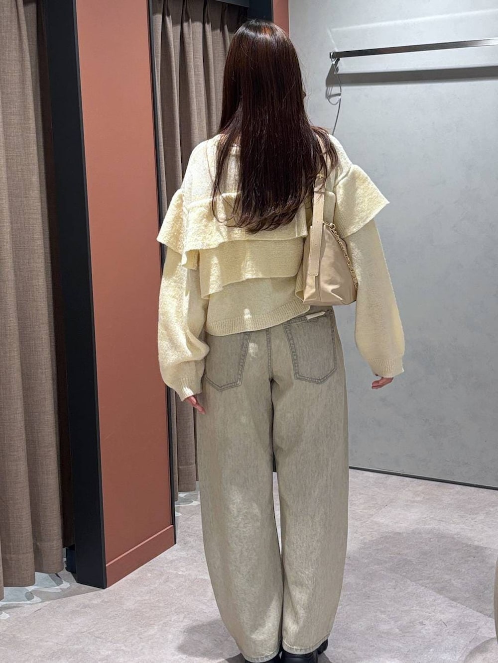 ベージュ系のデニムパンツ、ベージュ系のショルダーバッグ、ブラウン系のローファーを着用したレディースの冬コーディネートの3枚目の写真