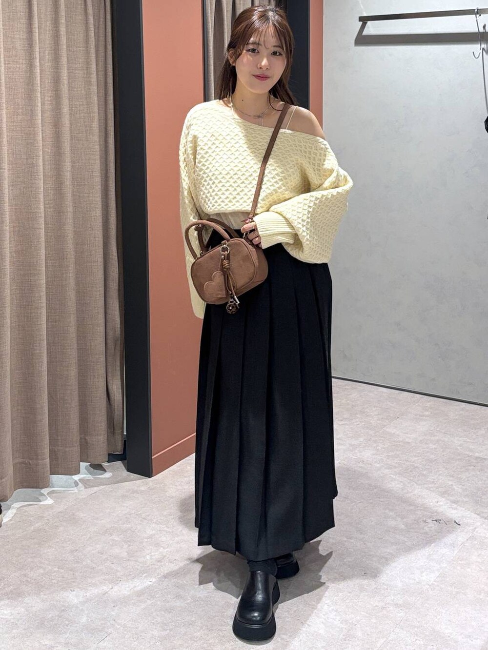 グレー系のスカート、ブラック系のサンダル、ホワイト系のキャミソールを着用したレディースの秋コーディネートの2枚目の写真