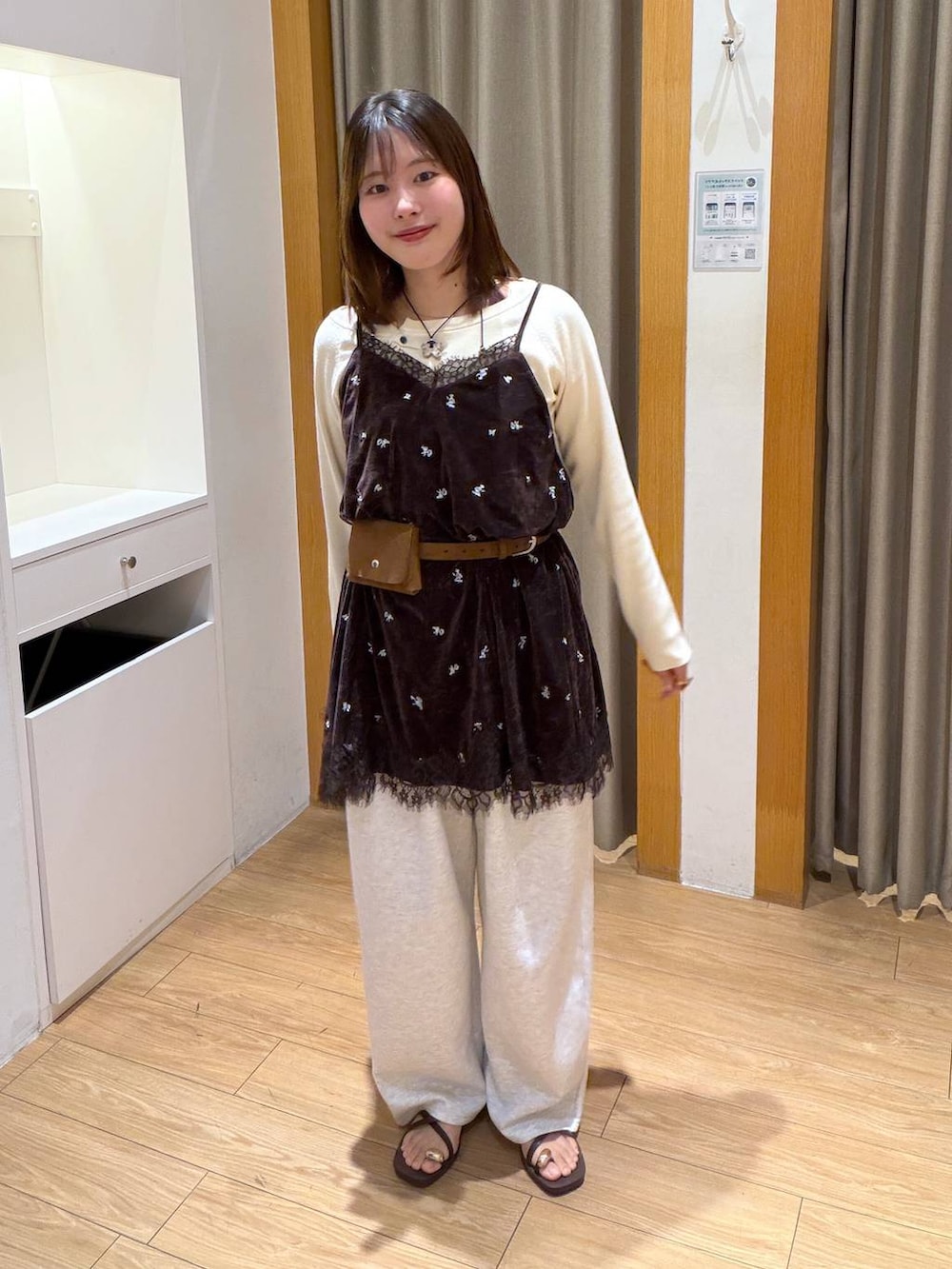 ホワイト系のニット/セーター、ブラウン系のワンピース、グレー系のスウェットパンツを着用したレディースの秋コーディネートの4枚目の写真