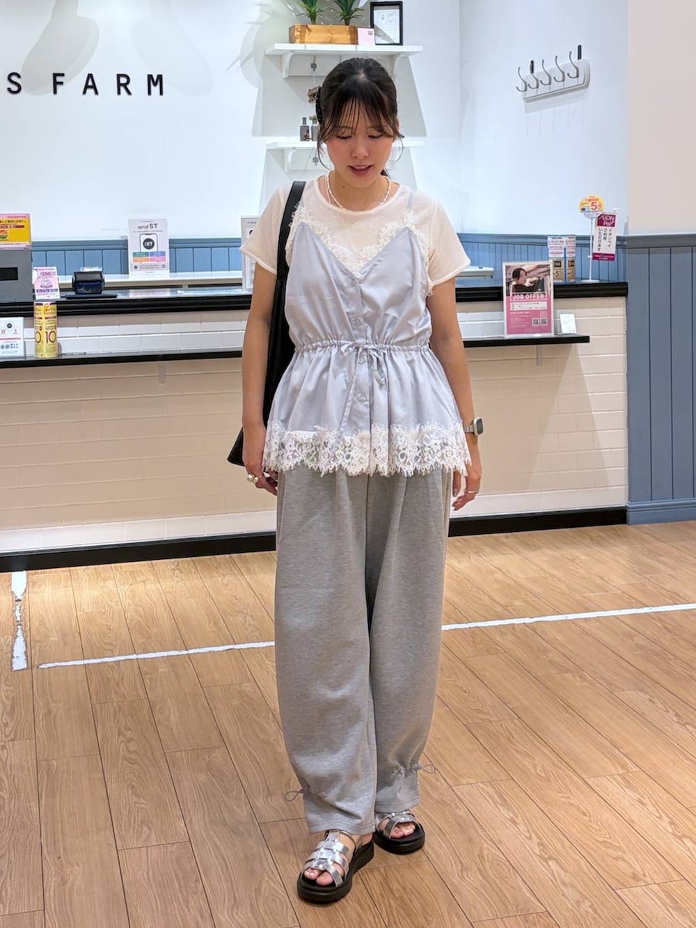 グレー系のスウェットパンツ、ブルー系のキャミソール、ブラック系のショルダーバッグを着用したレディースの夏コーディネートの4枚目の写真