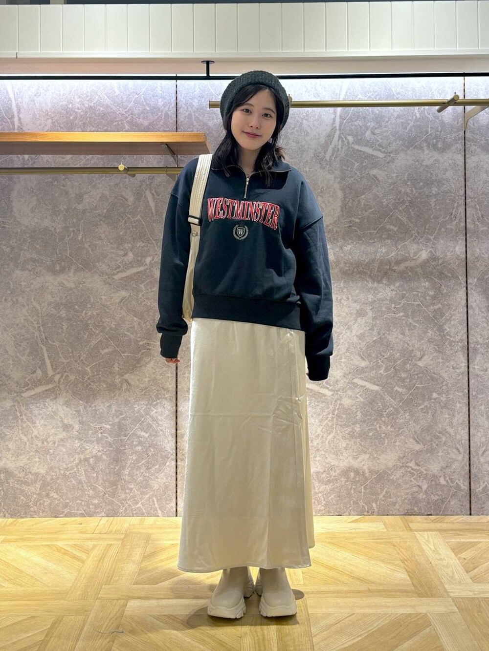 ホワイト系のブーツ、ホワイト系のスカート、ブルー系のスウェットを着用したレディースの秋コーディネートの2枚目の写真