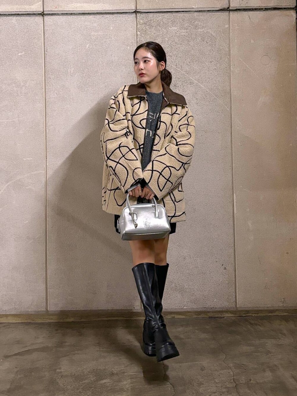 ブラウン系のブルゾン、ブラック系のブーツ、ブラック系のその他パンツを着用したレディースの秋コーディネートの2枚目の写真