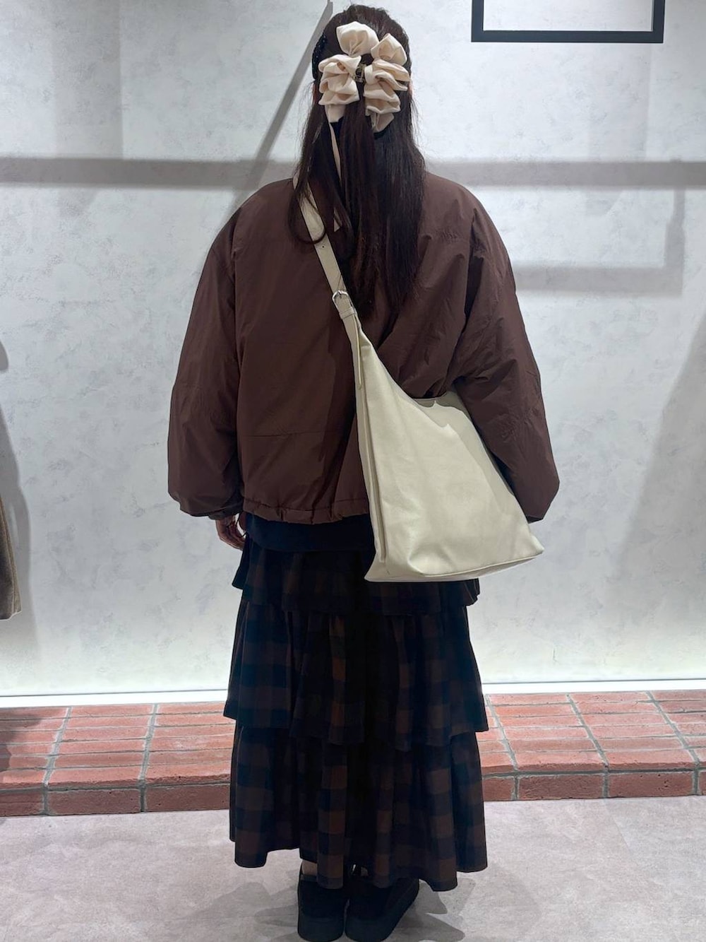 ホワイト系のショルダーバッグ、ブラウン系のその他アウター、ブラウン系のスカートを着用したレディースの秋コーディネートの3枚目の写真