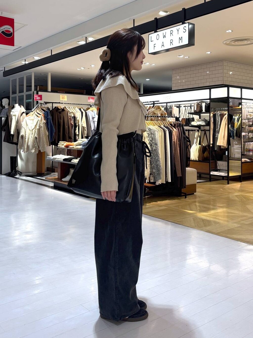 ベージュ系のニット/セーター、グレー系のその他パンツ、ブラック系のトートバッグを着用したレディースの冬コーディネートの4枚目の写真