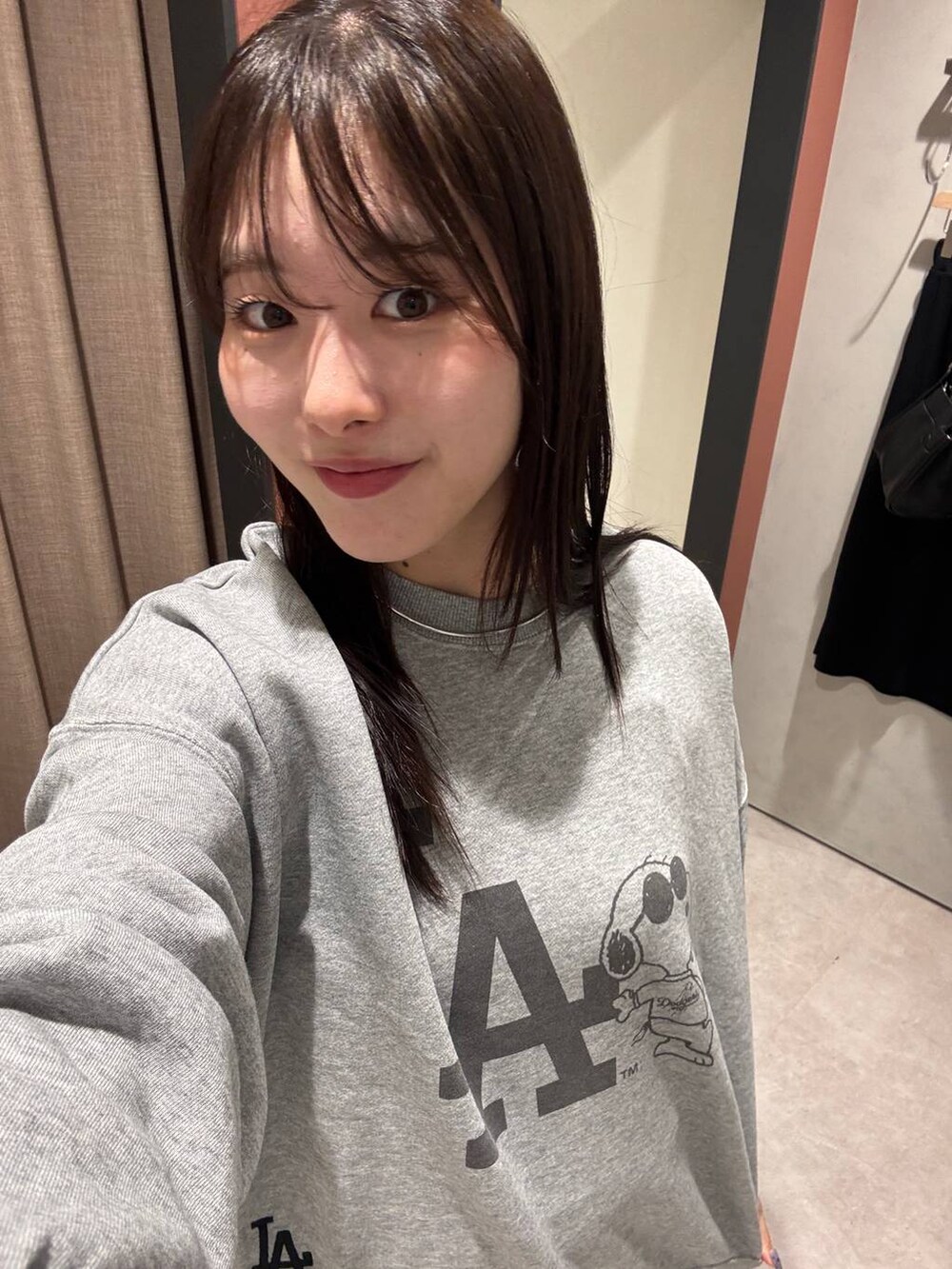 ホワイト系のスカート、シルバー系のスウェット、グレー系のチョーカーを着用したレディースの夏コーディネートの2枚目の写真