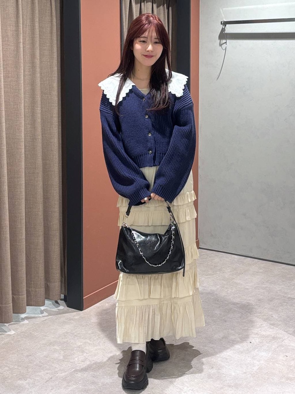 ブラック系のショルダーバッグ、ブラウン系のローファー、ホワイト系のスカートを着用したレディースの冬コーディネートの4枚目の写真