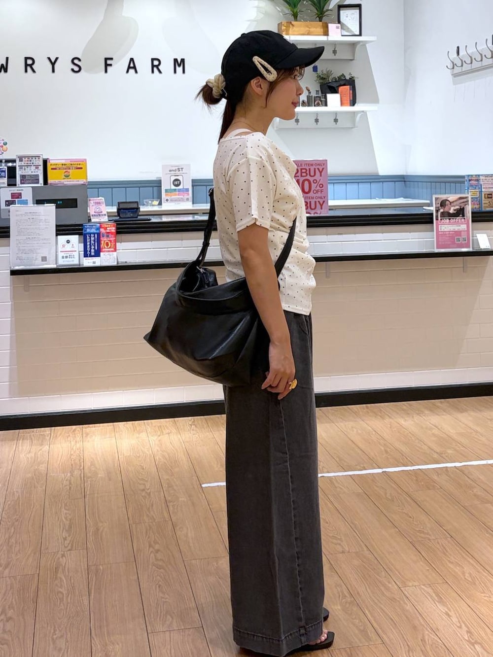 ベージュ系のTシャツ/カットソー、ブラック系のサンダル、ブラック系のショルダーバッグを着用したレディースの夏コーディネートの2枚目の写真