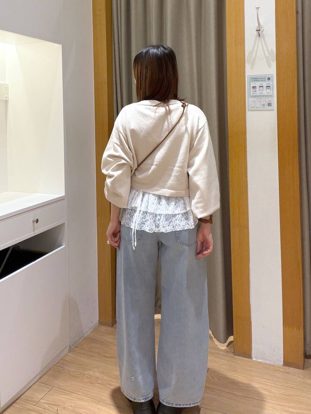 ブラウン系のボディバッグ/ウエストポーチ、ホワイト系のカーディガン/ボレロ、ホワイト系のTシャツ/カットソーを着用したレディースの秋コーディネートの2枚目の写真