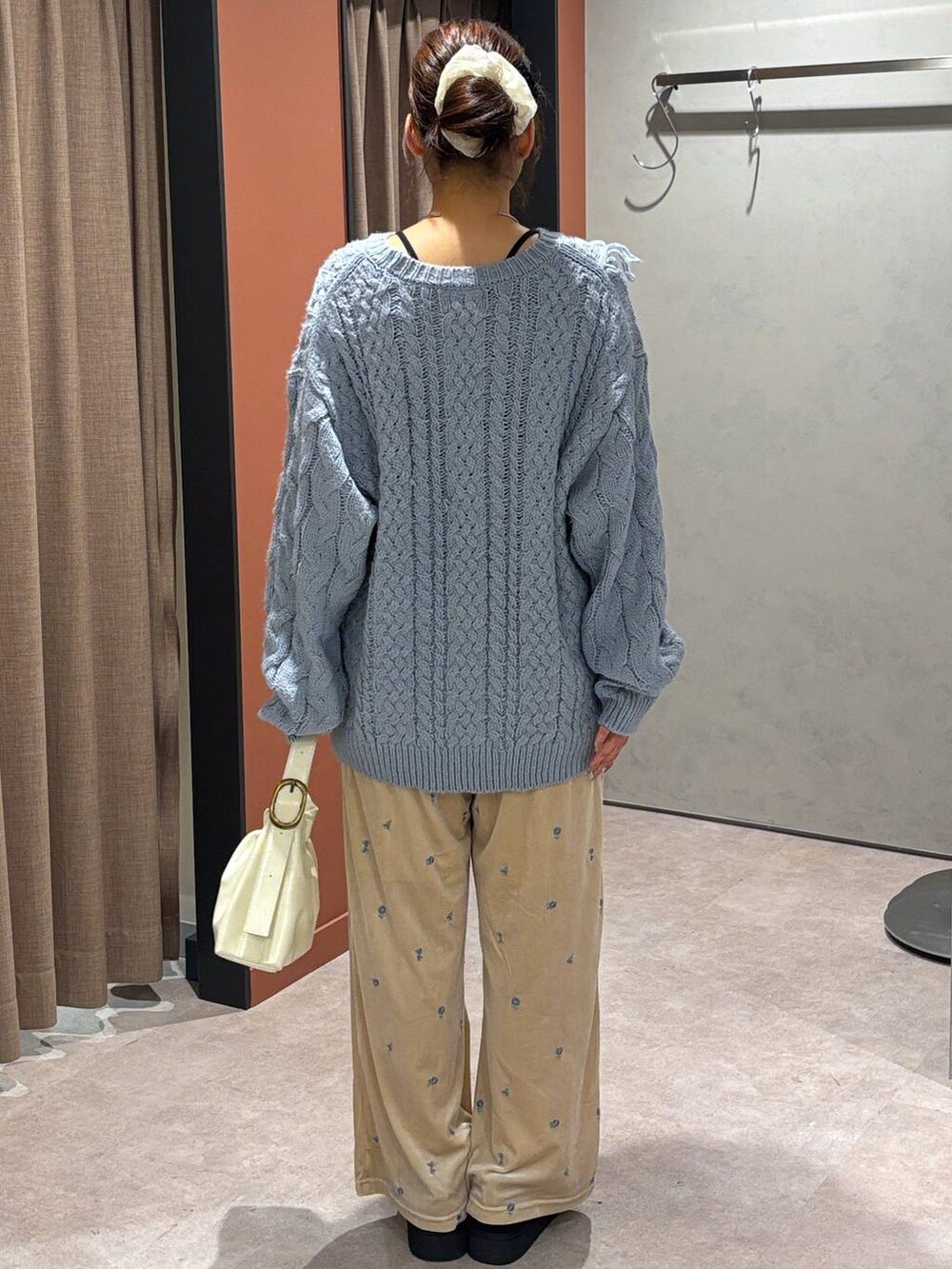 ブラック系のその他シューズ、ブルー系のニット/セーター、ホワイト系のショルダーバッグを着用したレディースの秋コーディネートの3枚目の写真