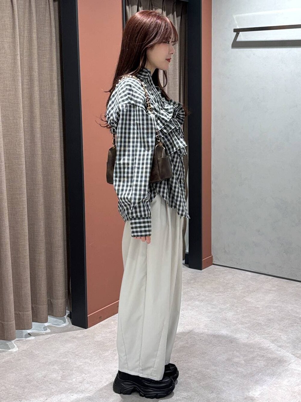 ブラウン系のその他パンツ、ブラウン系のショルダーバッグ、ブラウン系のローファーを着用したレディースの冬コーディネートの2枚目の写真