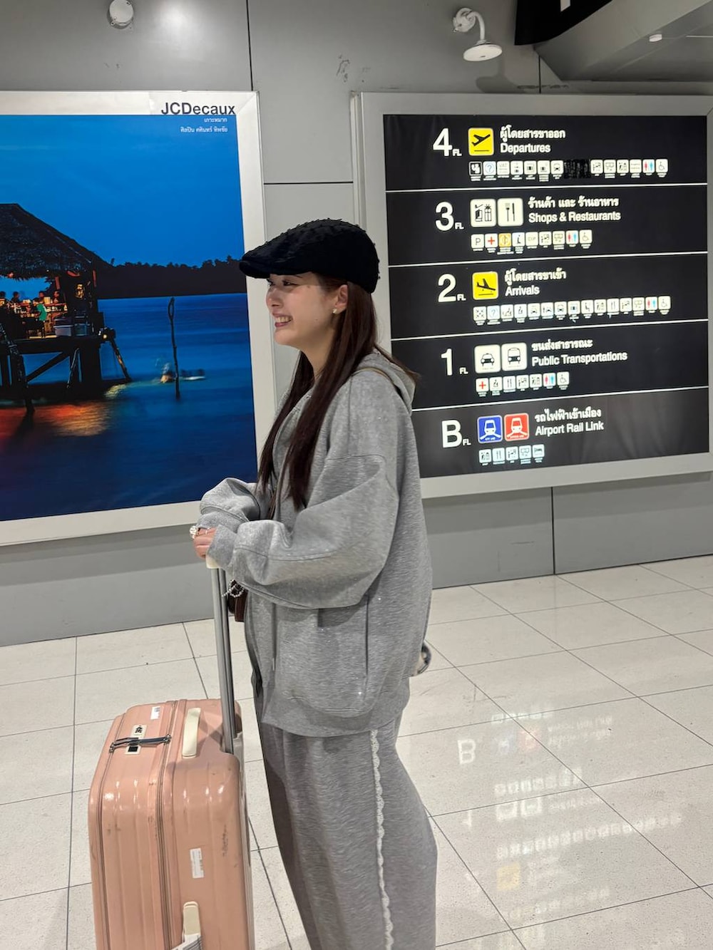 グレー系のスウェットパンツ、グレー系のパーカー、ゴールド系のボストンバッグを着用したレディースの冬コーディネートの3枚目の写真