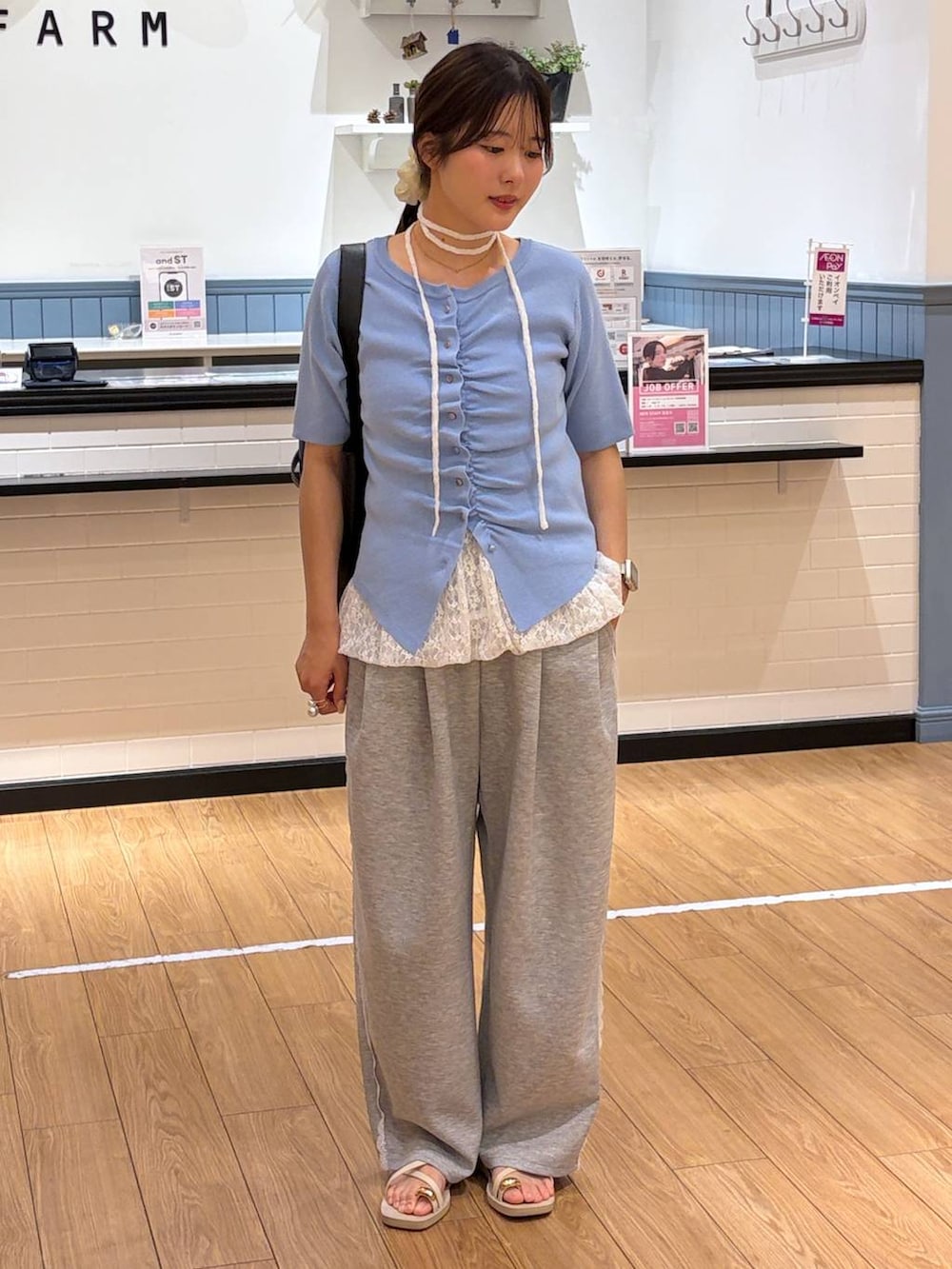 グレー系のスウェットパンツ、ブラック系のショルダーバッグ、ホワイト系のキャミソールを着用したレディースの春コーディネートの3枚目の写真