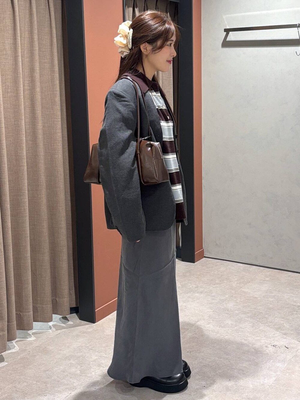 ブラック系のサンダル、グレー系のスカート、ブラウン系のニット/セーターを着用したレディースの秋コーディネートの2枚目の写真