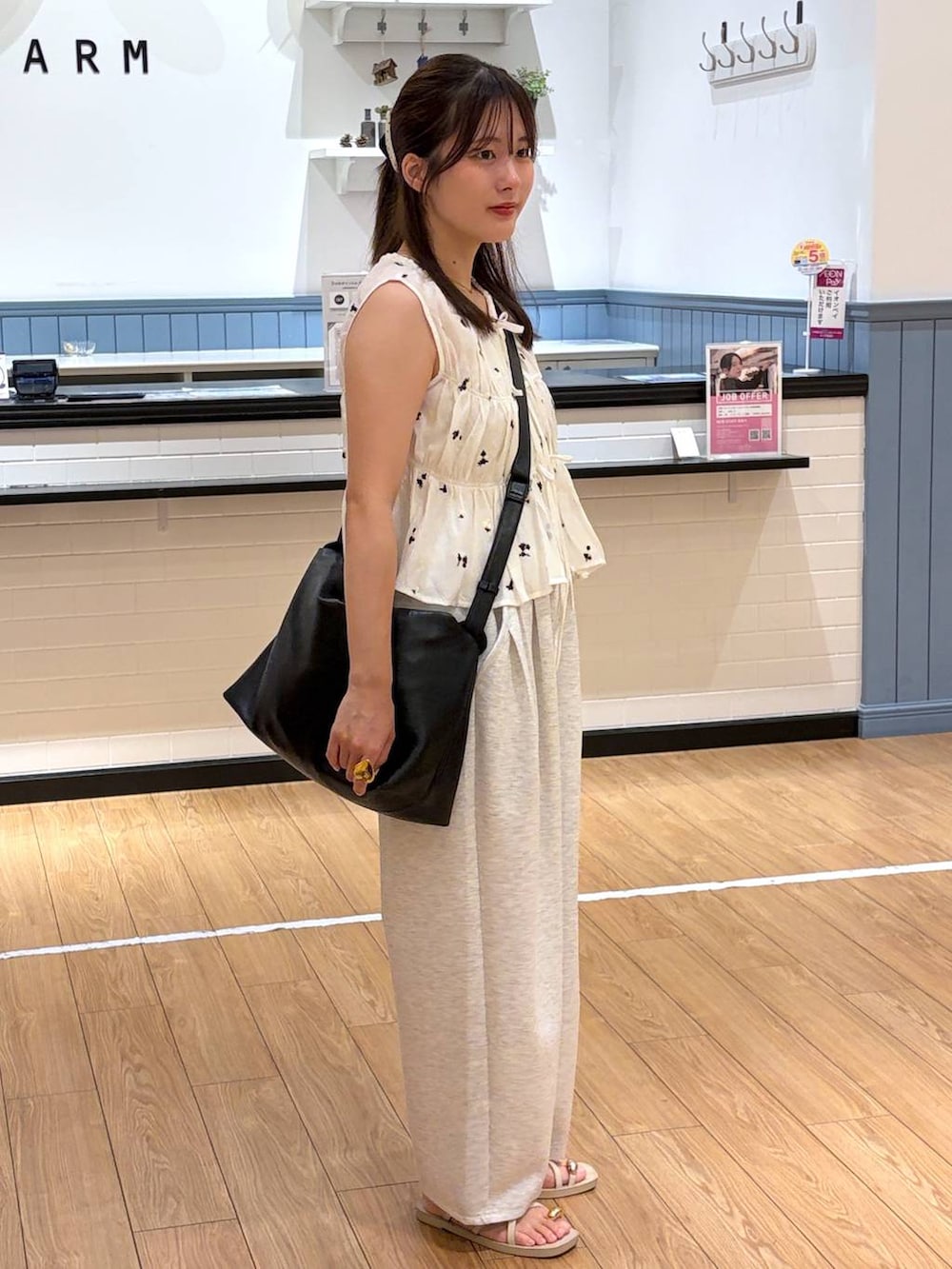 グレー系のスウェットパンツ、ホワイト系のサンダル、ブラック系のショルダーバッグを着用したレディースの夏コーディネートの2枚目の写真
