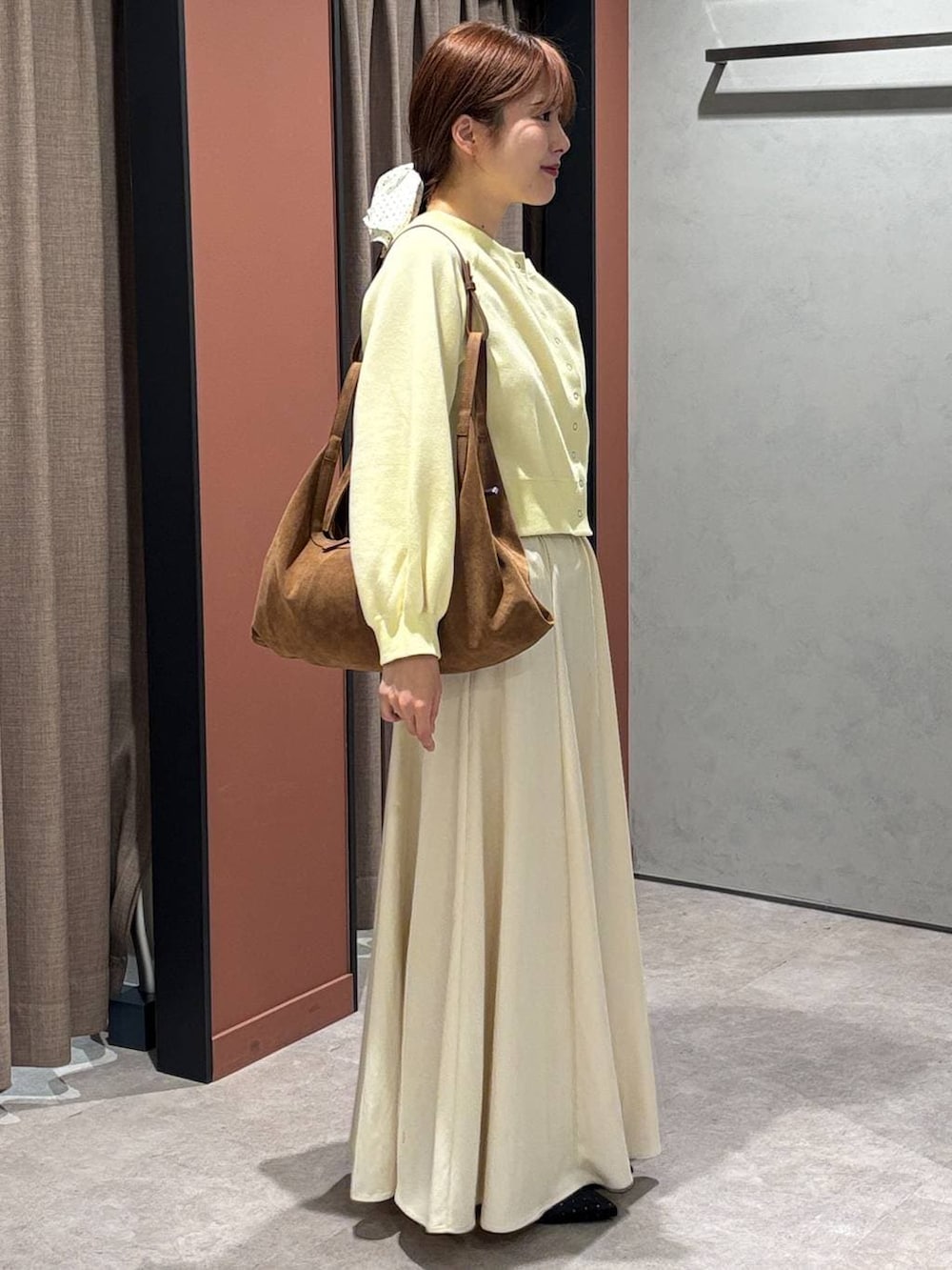 ブラック系のパンプス、ブラウン系のショルダーバッグ、イエロー系のスウェットを着用したレディースの春コーディネートの2枚目の写真