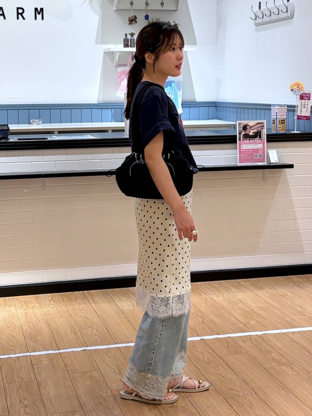 ブルー系のデニムパンツ、ホワイト系のサンダル、ホワイト系のスカートを着用したレディースの夏コーディネートの2枚目の写真