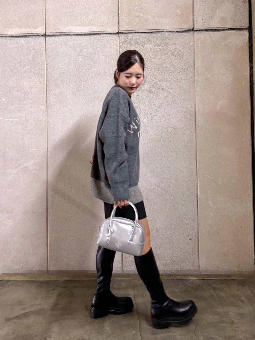 ブラック系のブーツ、グレー系のニット/セーター、ブラック系のその他パンツを着用したレディースの秋コーディネートの2枚目の写真