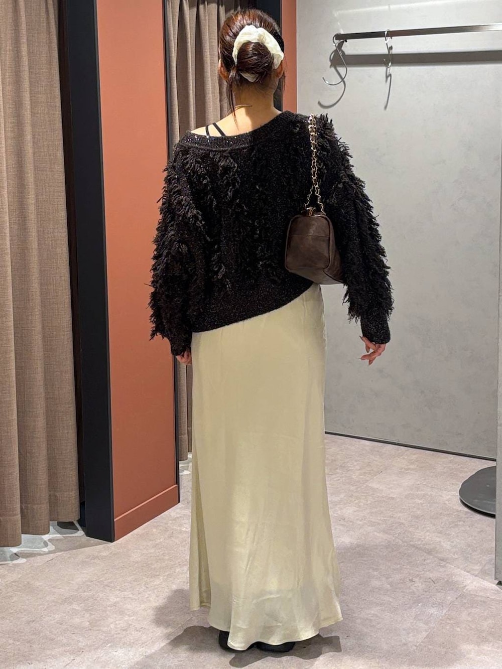 ブラック系のブーツ、ホワイト系のスカート、ブラウン系のカーディガン/ボレロを着用したレディースの秋コーディネートの3枚目の写真