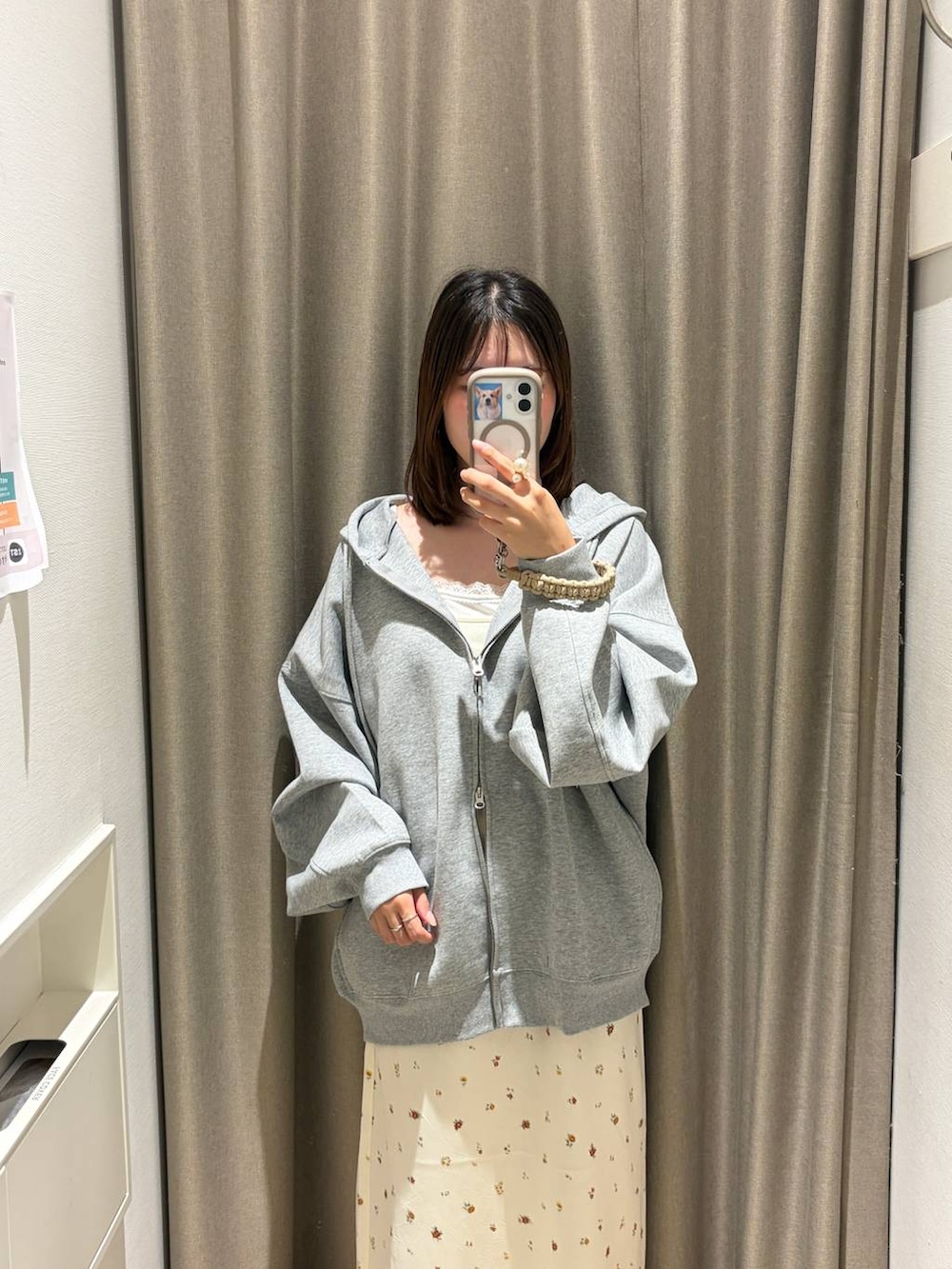 ホワイト系のスカート、グレー系のパーカー、ホワイト系のキャミソールを着用したレディースの夏コーディネートの2枚目の写真