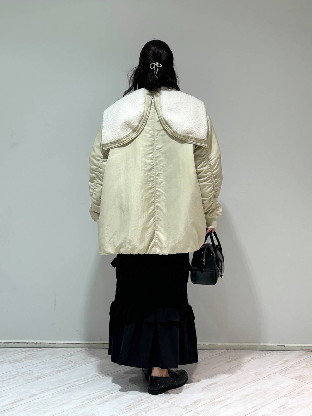 ホワイト系のブルゾン、グレー系のニット/セーター、ブラック系のローファーを着用したレディースの秋コーディネートの3枚目の写真