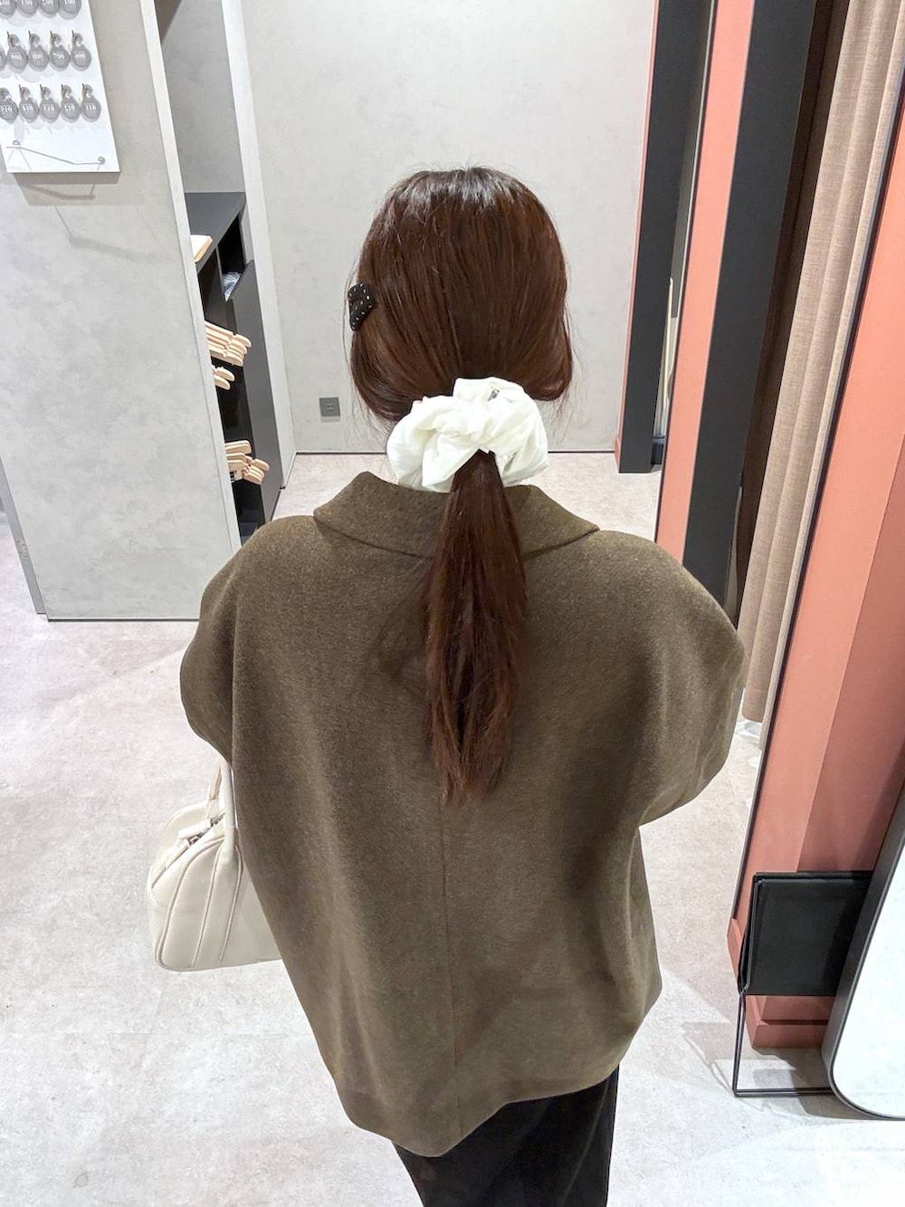 ブラウン系のその他アウター、ホワイト系のボストンバッグを着用したレディースの冬コーディネートの3枚目の写真