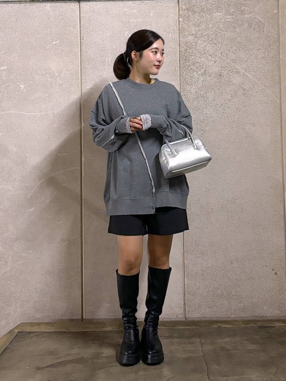 ブラック系のブーツ、シルバー系のボストンバッグ、グレー系のスウェットを着用したレディースの秋コーディネートの3枚目の写真