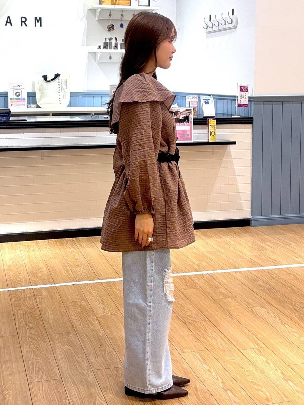 ブルー系のデニムパンツ、ブラック系のボディバッグ/ウエストポーチ、ブラウン系のサンダルを着用したレディースの春コーディネートの2枚目の写真