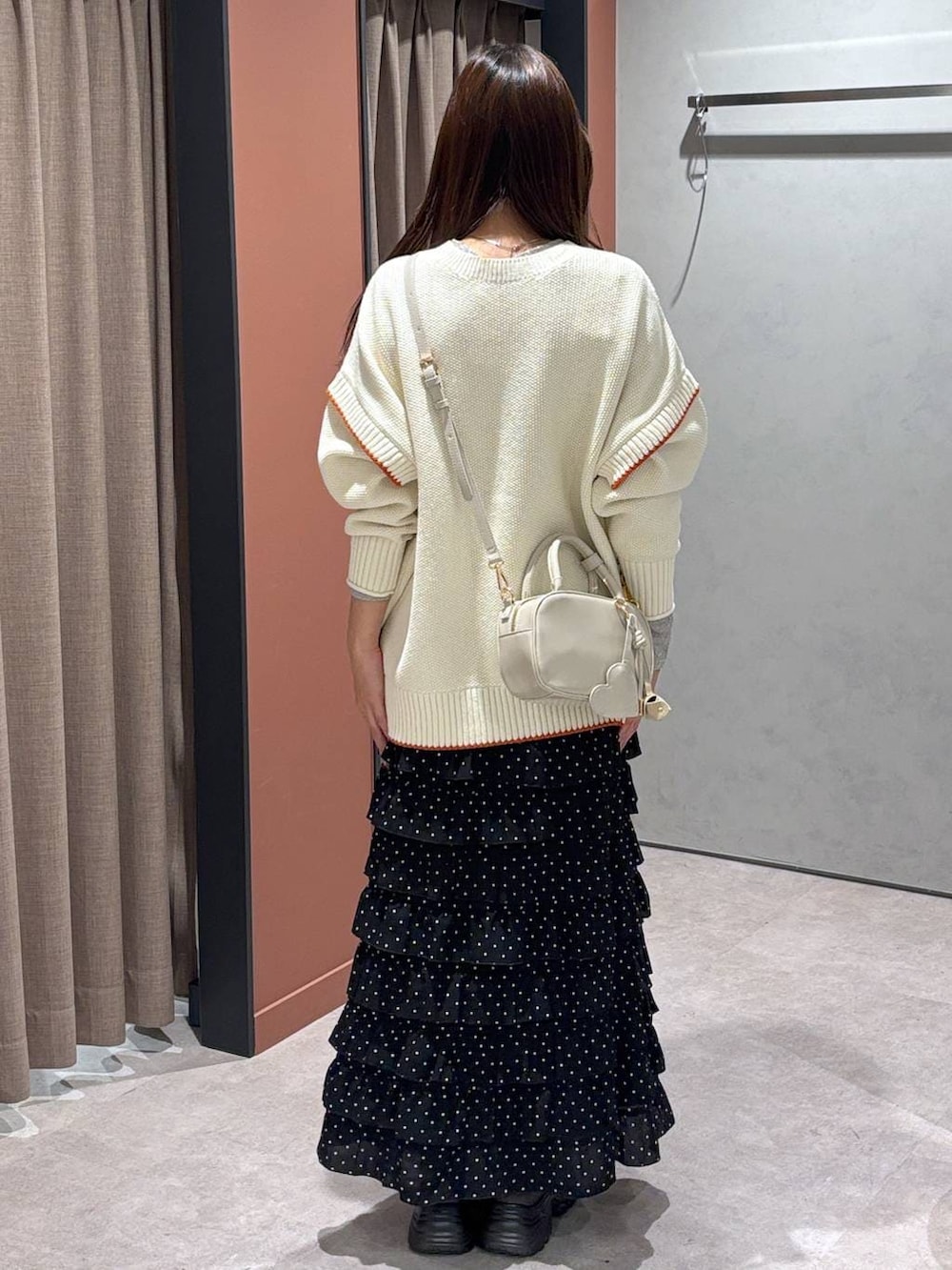 ブラウン系のブーツ、ホワイト系のニット/セーター、その他のスカートを着用したレディースの冬コーディネートの3枚目の写真