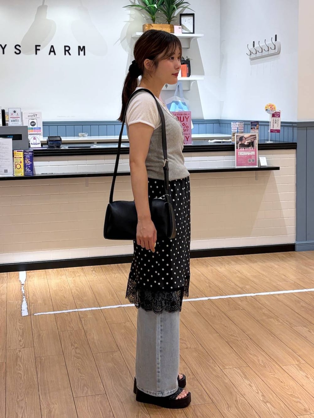 ブルー系のデニムパンツ、ブラック系のサンダル、グレー系のタンクトップを着用したレディースの夏コーディネートの2枚目の写真
