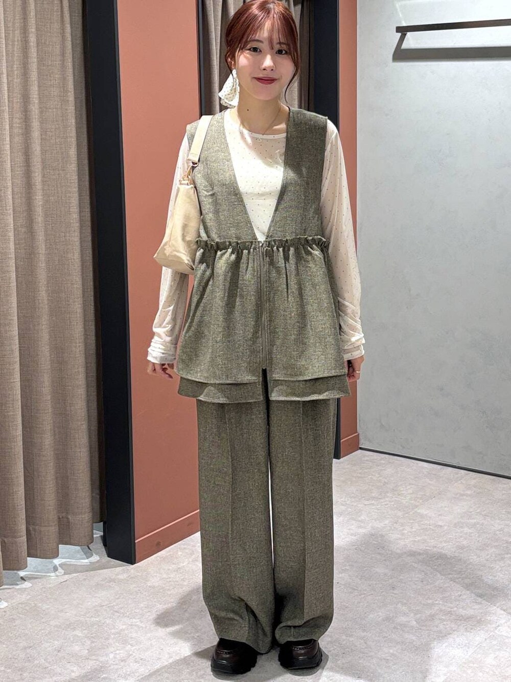 ブラウン系のデニムパンツ、ブラウン系のベスト、ホワイト系のTシャツ/カットソーを着用したレディースの冬コーディネートの4枚目の写真