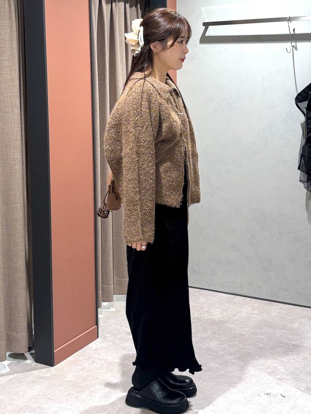 ブラック系のサンダル、ブラック系のスカート、ブラウン系のブルゾンを着用したレディースの秋コーディネートの2枚目の写真