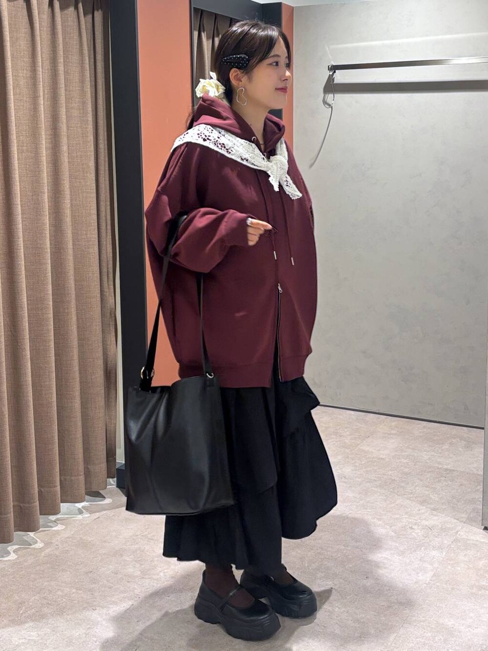 ブラック系のスニーカー、レッド系のパーカー、ブラック系のショルダーバッグを着用したレディースの秋コーディネートの2枚目の写真