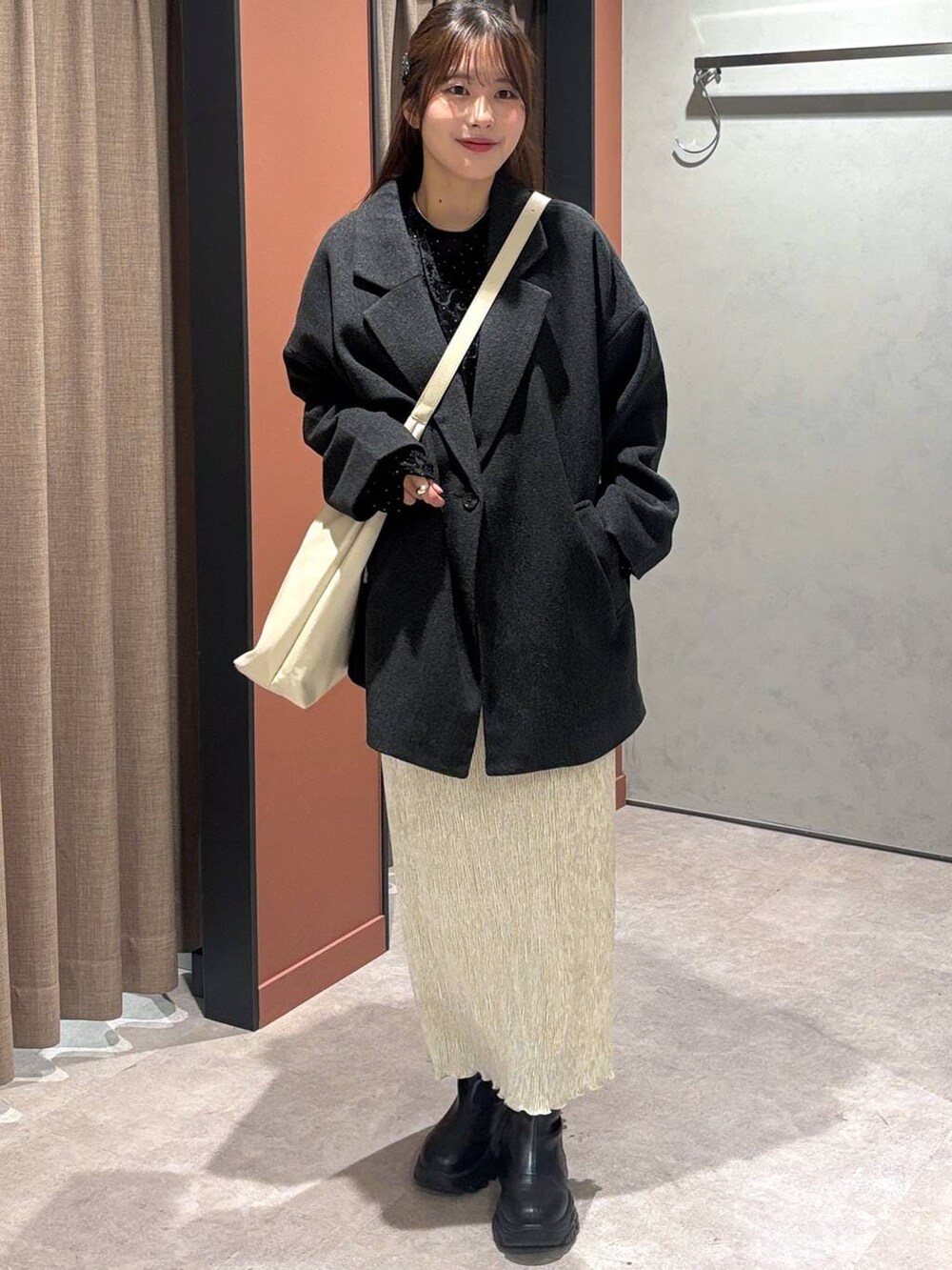 ブラック系のショルダーバッグ、ブラック系のブーツ、ホワイト系のスカートを着用したレディースの冬コーディネートの4枚目の写真