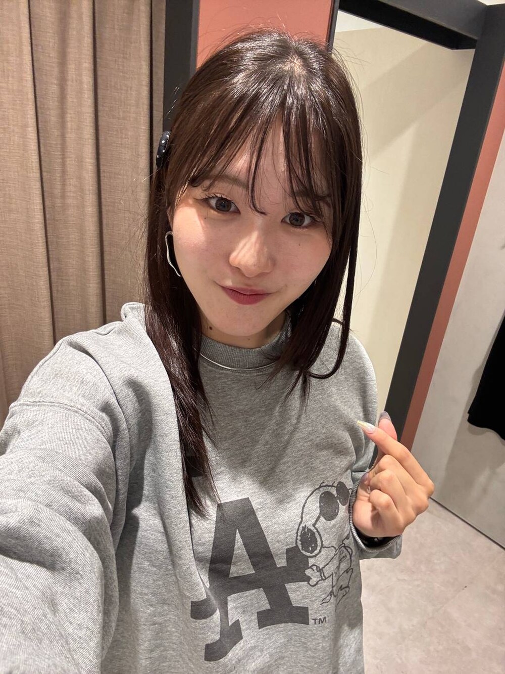 ホワイト系のスカート、シルバー系のスウェット、グレー系のチョーカーを着用したレディースの夏コーディネートの4枚目の写真