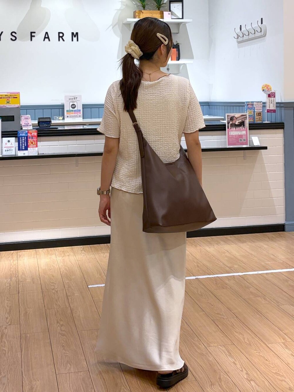 ホワイト系のカーディガン/ボレロ、ブラウン系のショルダーバッグ、ホワイト系のスカートを着用したレディースの夏コーディネートの3枚目の写真
