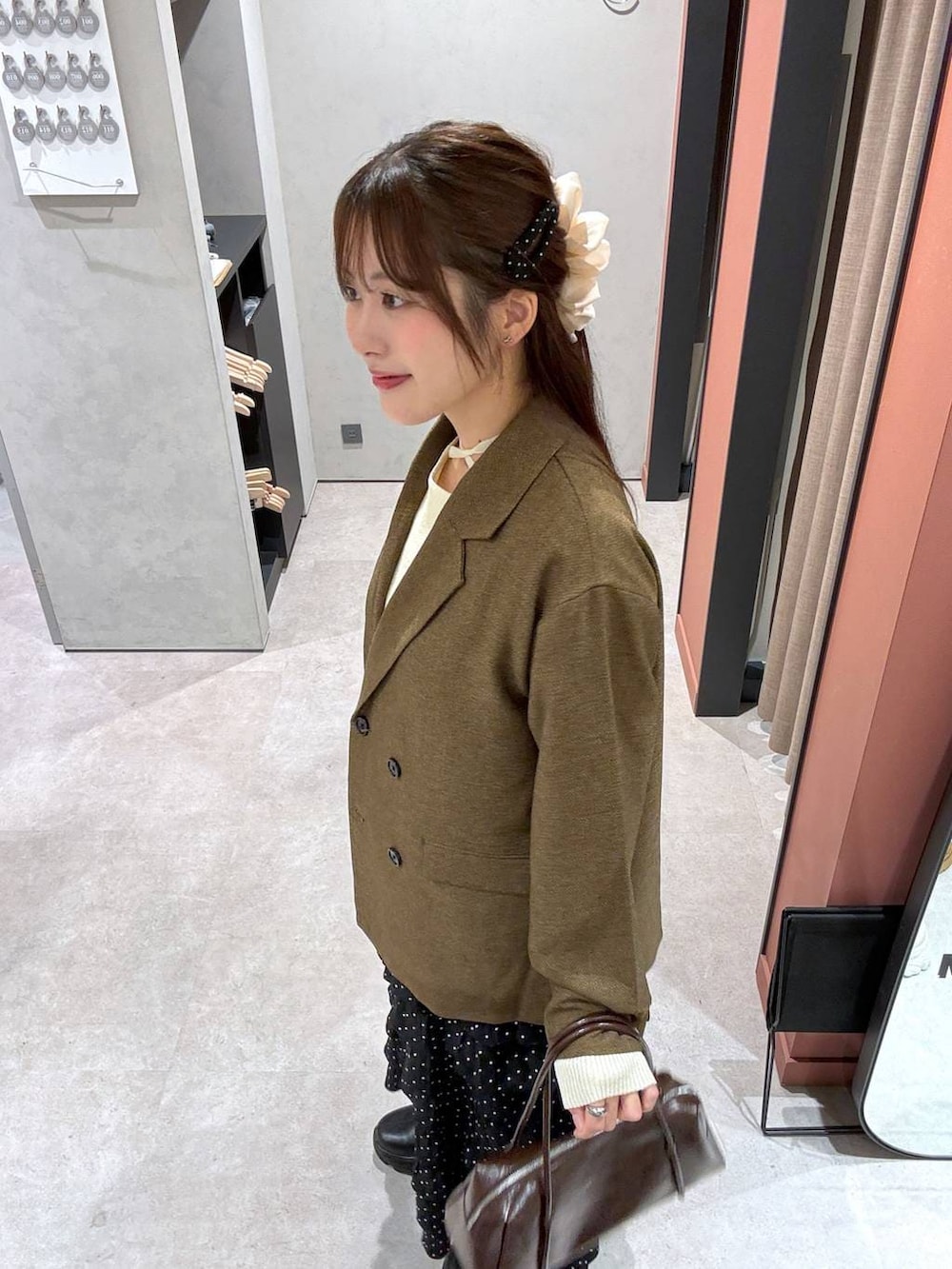 ベージュ系のテーラードジャケット、ベージュ系のニット/セーターを着用したレディースの冬コーディネートの2枚目の写真