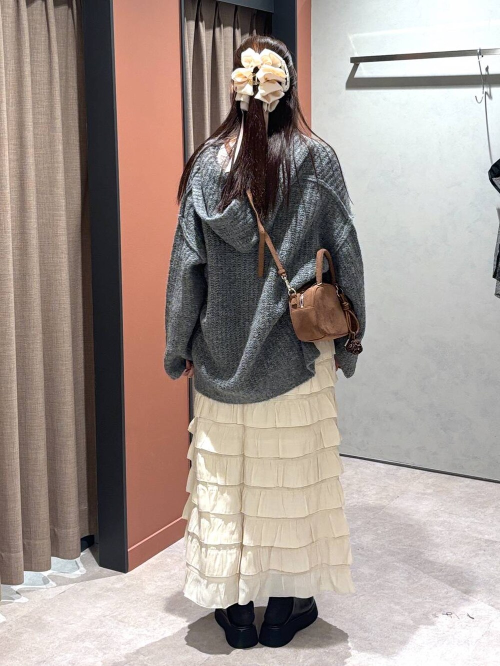 ホワイト系のスカート、ブラック系のサンダル、グレー系のニット/セーターを着用したレディースの秋コーディネートの2枚目の写真