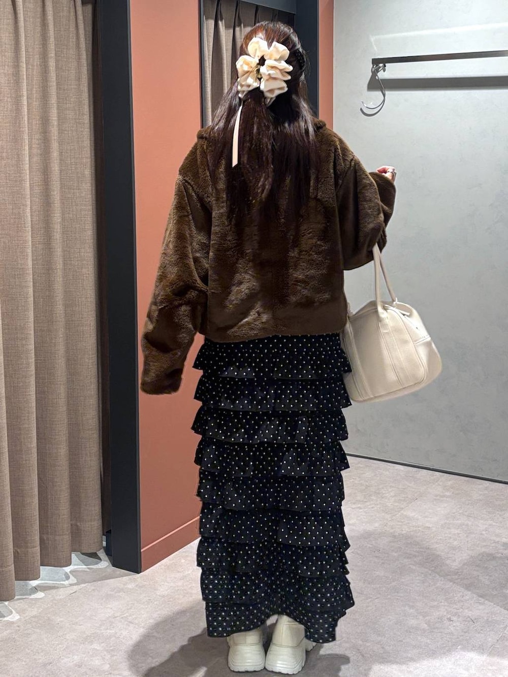 ホワイト系のブーツ、ブラウン系のブルゾン、その他のスカートを着用したレディースの冬コーディネートの3枚目の写真