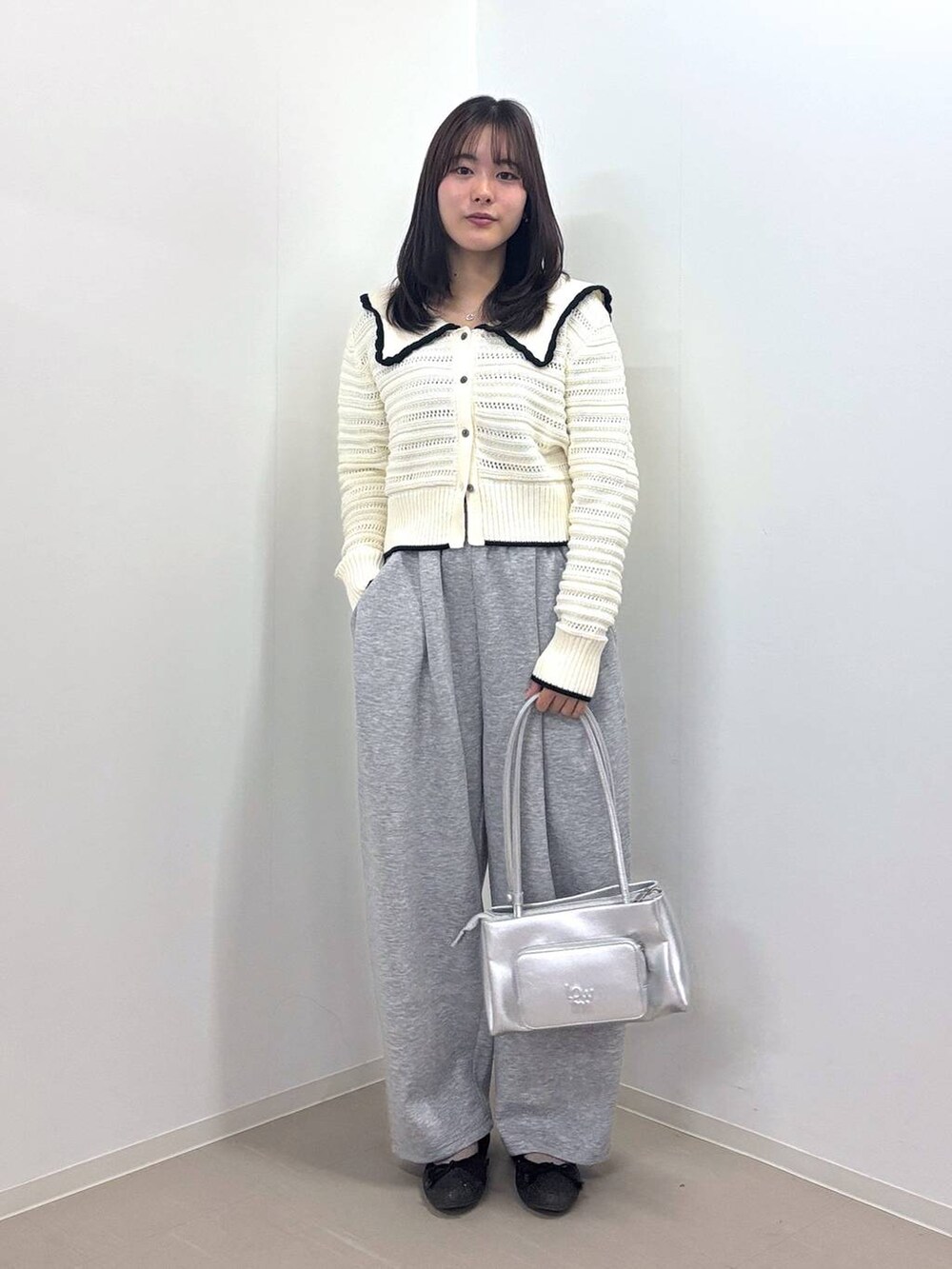 シルバー系のショルダーバッグ、ホワイト系のニット/セーター、グレー系のスウェットパンツを着用したレディースの春コーディネートの4枚目の写真