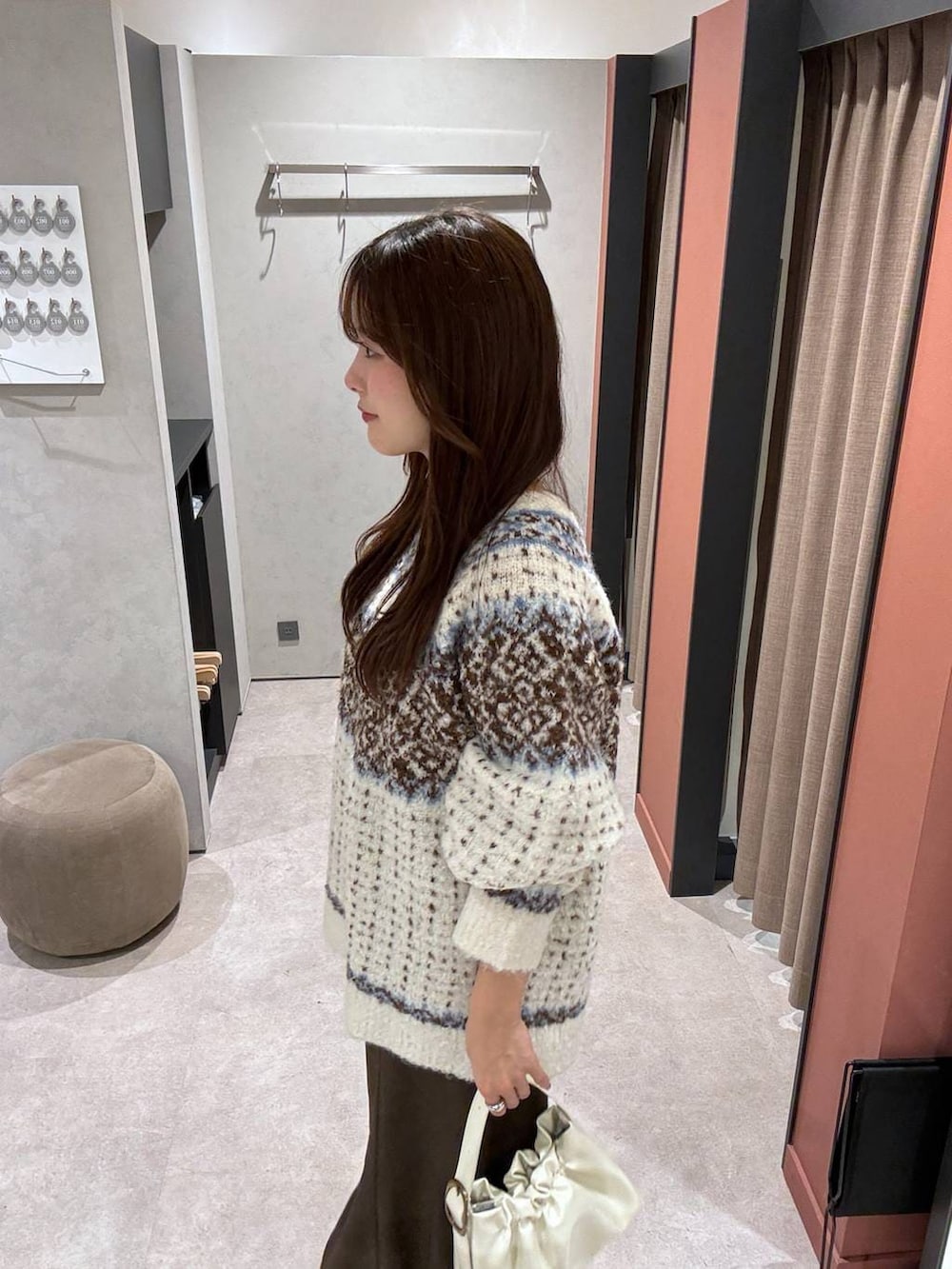 ホワイト系のショルダーバッグ、ホワイト系のニット/セーターを着用したレディースの冬コーディネートの2枚目の写真