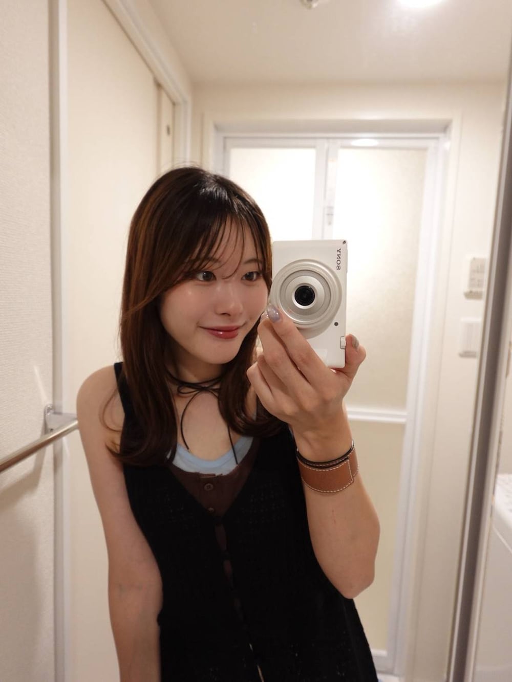 ブラウン系のタンクトップを着用したレディースの夏コーディネートの2枚目の写真