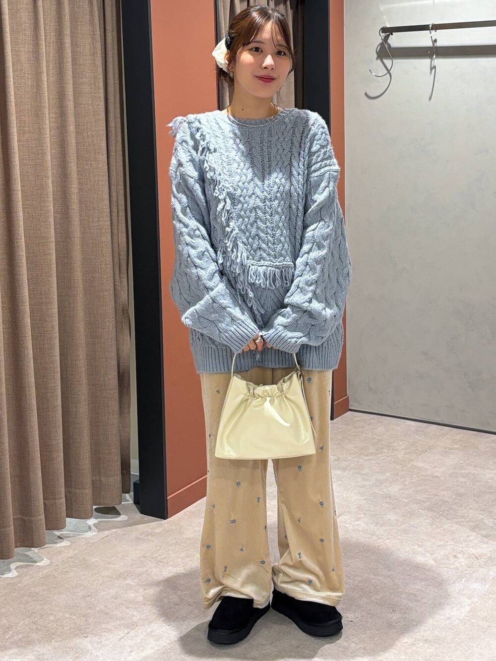 ブラック系のその他シューズ、ブルー系のニット/セーター、ホワイト系のショルダーバッグを着用したレディースの秋コーディネートの4枚目の写真