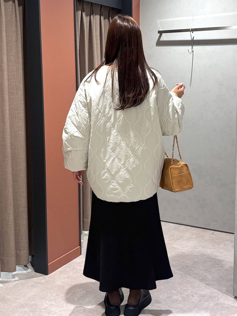 ブラック系のサンダル、ホワイト系のブルゾン、ブラック系のスカートを着用したレディースの冬コーディネートの3枚目の写真