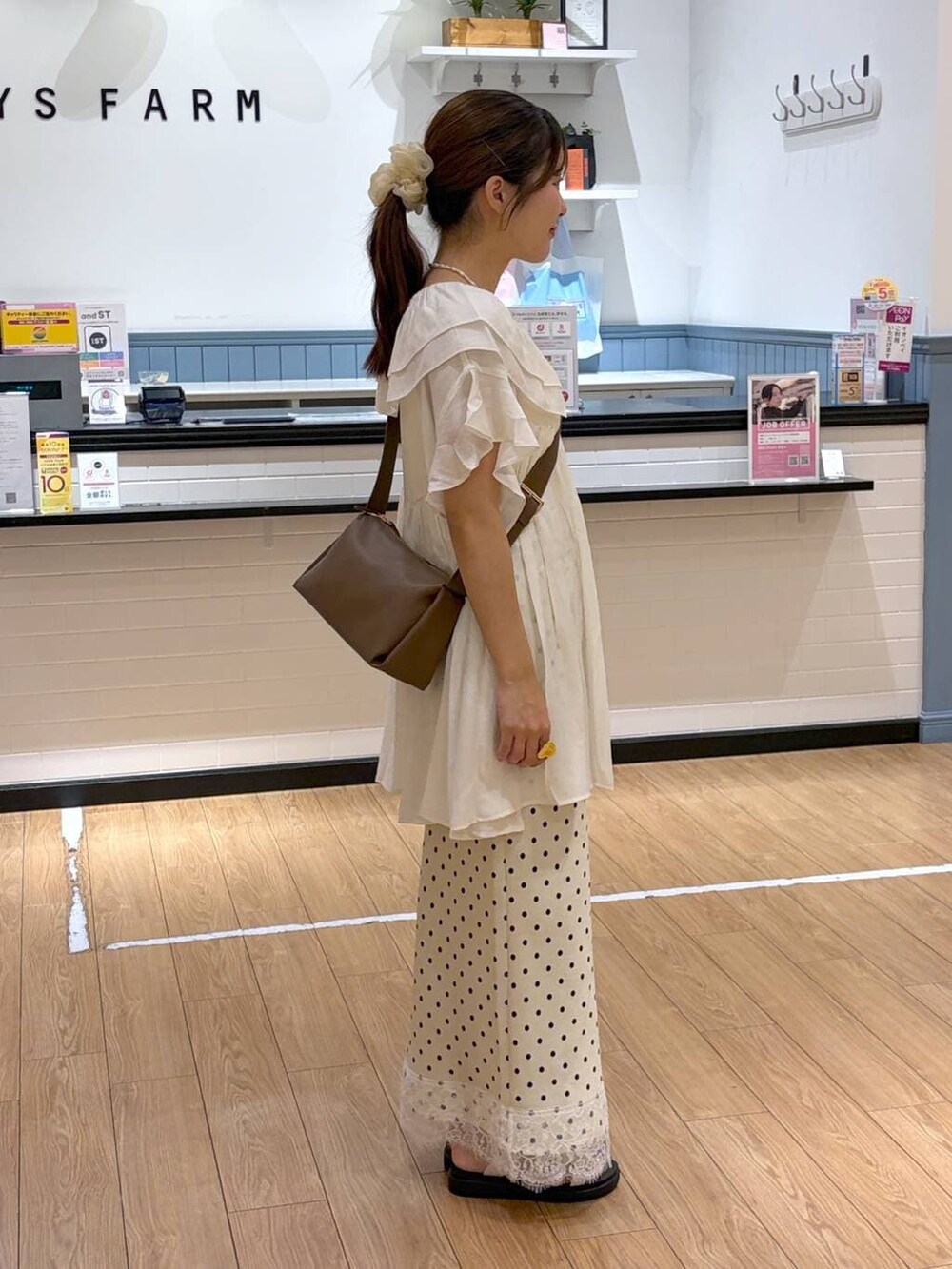 ホワイト系のサンダル、ブラウン系のショルダーバッグ、ホワイト系のスカートを着用したレディースの夏コーディネートの2枚目の写真