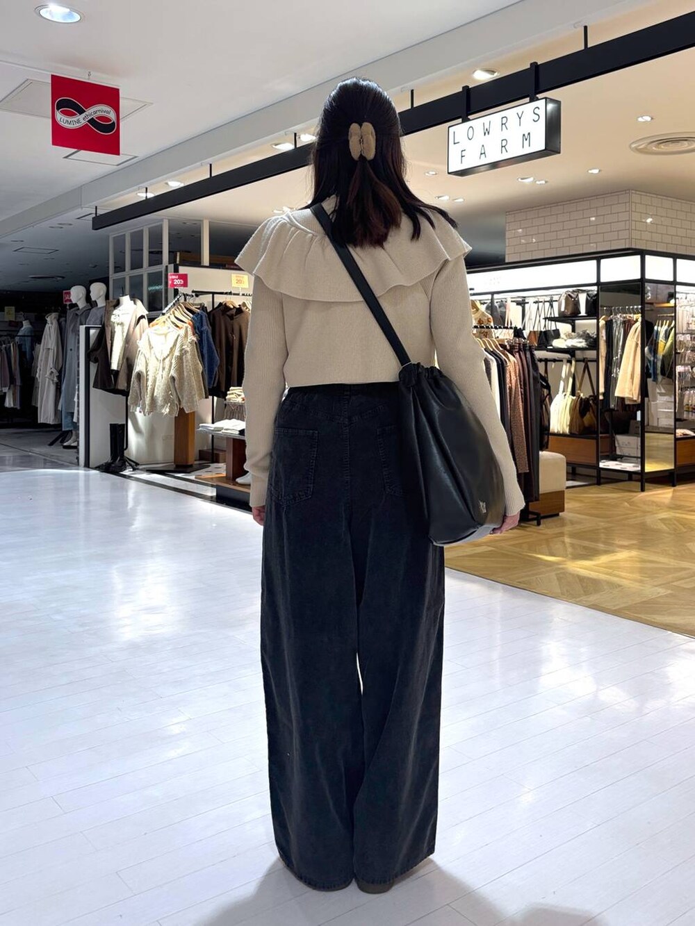 ベージュ系のニット/セーター、グレー系のその他パンツ、ブラック系のトートバッグを着用したレディースの冬コーディネートの3枚目の写真